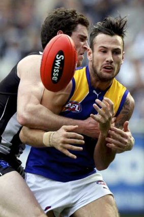 Collingwood's Tyson Goldsack lays a tackle on West Coast's Chris Masten in the qualifying final at the MCG.