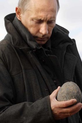 Russian Prime Minister Vladimir Putin holds an artefact at a research station at the mouth of the Lena River.