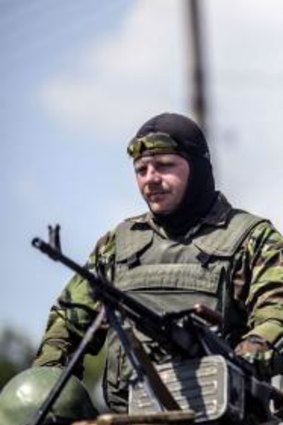 A Ukrainian soldier near Donetsk on top a humvee with a Ukrainian flag behind him on Thursday.