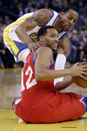 Philadelphia 76ers guard Evan Turner looks to pass after picking up a loose ball next to Golden State Warriors swingman Andre Iguodala.