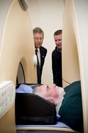 John Pauley, who has a family history of Alzheimer's Disease, gets a brain scan as part of new research into the disease, while science minister Bill Marmion and Oceanic Medical Imaging director Chris Wood look on.