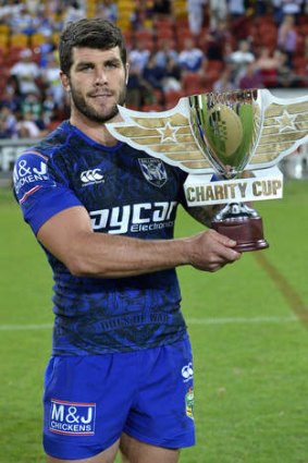 Leading man: Michael Ennis holds up the inaugural Charity Cup winners trophy after the NRL trial match against Melbourne Storm.