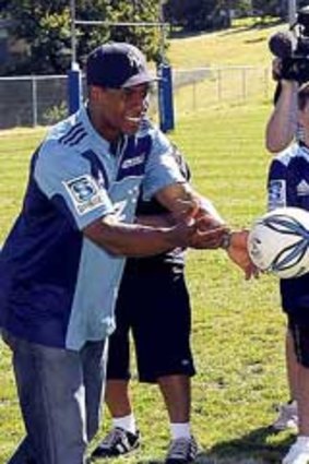 Passing tips . . . New York Yankees star Curtis Granderson, watched by Prime Minister John Key's son Max, throws around a rugby ball at a Blues training session.