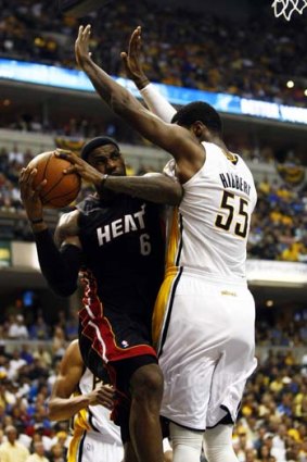 Miami Heat forward LeBron James (L) collides with Indiana Pacers center Roy Hibbert.