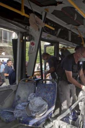 Aftermath ... Police officers examine the destroyed bus at the site of the bombing in Tel Aviv.