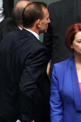Ships passing ... Tony Abbott and Julia Gillard cross paths in the Parliament.