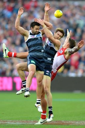 Collision course: Cats Jimmy Bartel (left) and Tom Lonergan crunch Swan Jesse White.