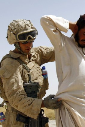 A US soldier searches an Afghan man for weapons in Helmand province, Afghanistan.