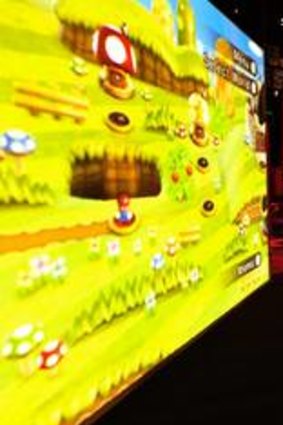 A visitor to the <i>Game Masters</i> exhibition at ACMI tries out one of the 125 playable games on show.
