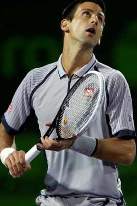 Novak Djokovic fades back for an overhead.
