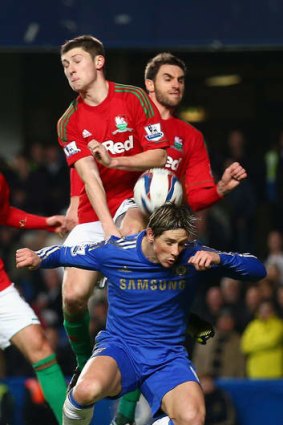 Up, up: Ben Davies leaps over Fernando Torres.