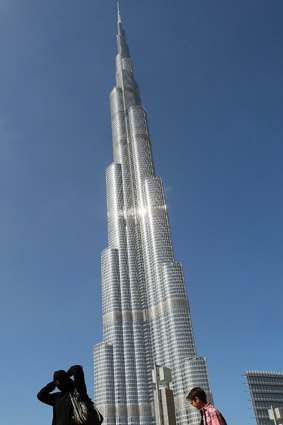 An Emirati woman and her children walk past Burj Dubai, the world's tallest tower.