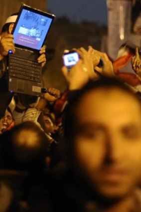 An opposition supporter holds up a laptop showing images of celebrations in Cairo's Tahrir Square, after Egypt's President Hosni Mubarak resigned.