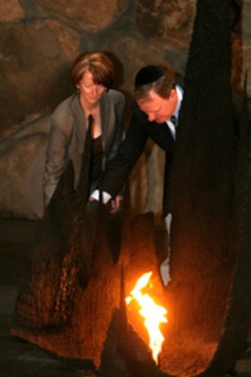 Julia Gillard and Peter Costello rekindle the eternal flame at Jerusalem's Yad Vashem Holocaust museum. Picture: Gali Tibbon.