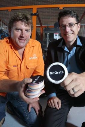 ADdysk managing director Dean Groening shows one of his clients McGrath Estate Agents director Chris Dixon a sample of his small advertising disk that will be placed on top of coffee lids at his factory in Mitchell.
