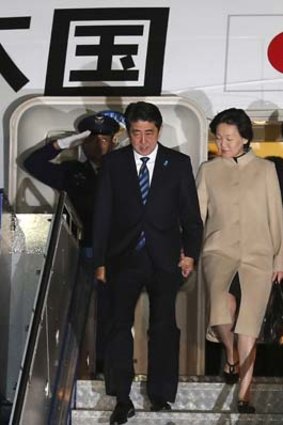 The first Japanese leader to address Australia's Parliament: Prime Minister Shinzo Abe, left, and his wife Akie Abe arrive in Canberra on Monday night.