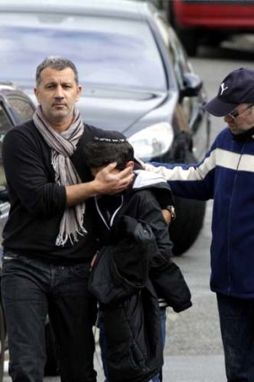 Blind panic ... a distraught boy is comforted as he leaves the Ozar Hatorah Jewish school after the massacre.