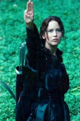 Hunger Games narrator Katniss Everdeen shows strength with the three-finger salute.
