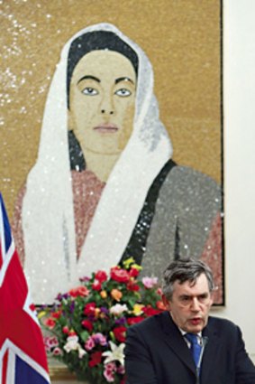 Shadow of terror ... Gordon Brown speaks in front of a portrait of the slain Pakistani leader Benazir Bhutto yesterday.