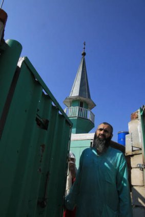 A member of an underground sect stands at the gate of a house outside Kazan.