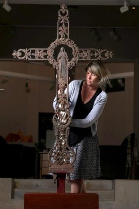 Slice of history: Gallery manager Ruth Lovell with the former grave-site cross, which is to be auctioned.