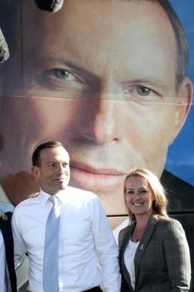 Opposition Leader Tony Abbott and Liberal candidate Fiona Scott pose with the campaign bus, in Penrith, NSW.