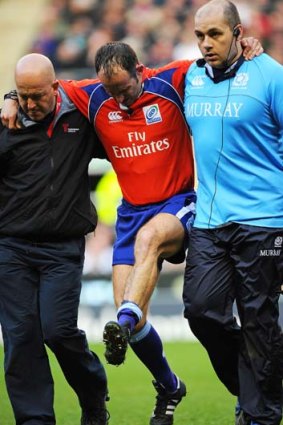 French referee Romain Poite is helped off the pitch after he was injured.