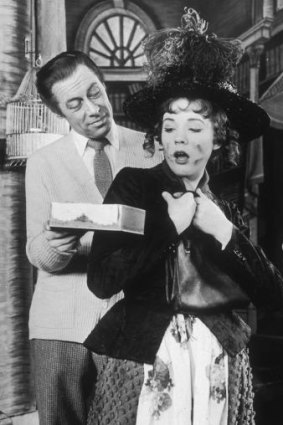Rex Harrison offers Julie Andrews a gift in a scene from the Broadway musical <i>My Fair Lady</i> at the Mark Hellinger Theatre in New York.