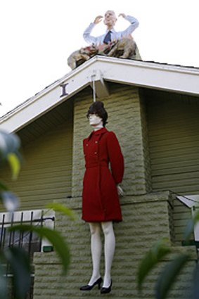 A mannequin portraying Sarah Palin hangs by a noose, while a mannequin portraying John McCain protrudes from the chimney of a house in West Hollywood.