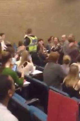 A grainy still from an amateur video shows Sophie Mirabella (right of the man in the yellow vest) after rowdy interjections.