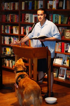 Former US Army captain Luis Carlos Montalvan reads a passage from his book <I>Until Tuesday</I>, as his dog Tuesday looks on, 2011.