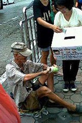 A homeless Thai man donates to flood victims in this photo posted on Facebook.