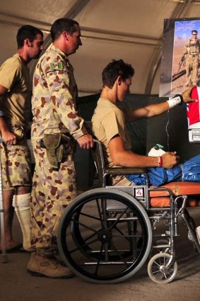Two wounded soldiers quietly farewell Private Tomas Dale and Private Grant Kirby, in Tarin Kot, Afghanistan.