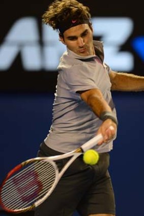 Roger Federer hits a return against Canada's Milos Raonic.