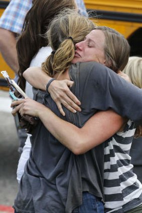 Flood evacuees hug at a drop off point for those rescued after days of flooding, at a high school in Niwot, Colorado.