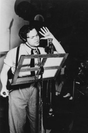 Orson Welles broadcasting his radio show of H.G. Wells' science-fiction novel the <i>War of the Worlds</i>.