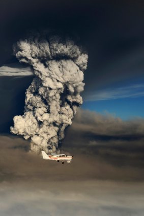 A plane flies past smoke plume from the eruption of the Grimsvotn volcano, under the Vatnajokull glacier in southeast Iceland.