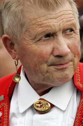A man wearing an earring shaped like a skimming spoon.