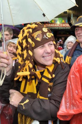 Still smiling: It rained on the AFL parade today.