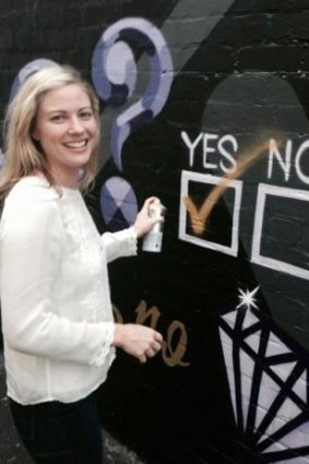 Bree Pearce sprays her answer on the Highgate mural.