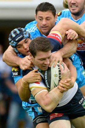 Under pressure: Rory Kostjasyn of the Cowboys is tackled  by a pack of Titans players.