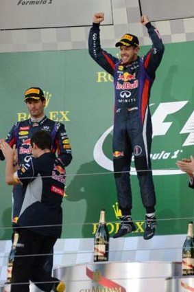 Sebastian Vettel celebrates his victory as second-placed Mark Webber (left) and third-placed Romain Grosjean look on.