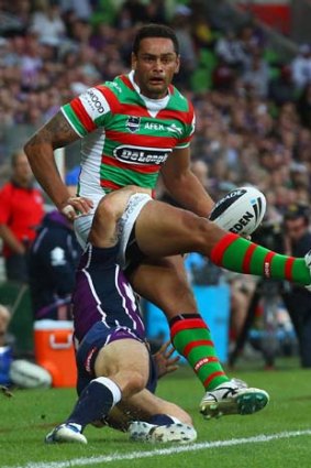John Sutton of the Rabbitohs is tackled by Cooper Cronk.