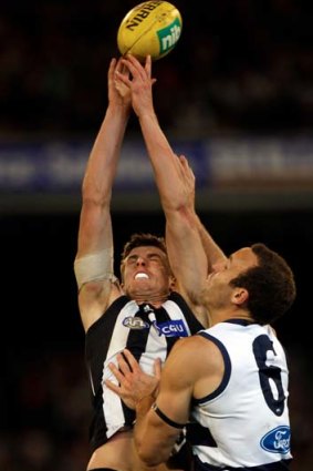 Magpies ruckman Cameron Wood is spoiled by Cats big man Brad Ottens.
