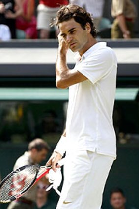 A disappointed Roger Federer walks off the court.