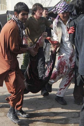 Afghans remove bodies and help the wounded after the suicide bombing at the Abul Fazl Shrine  in Kabul.