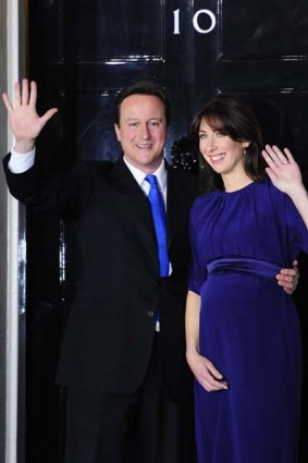 David Cameron, accompanied by his wife Samantha, waves in front of 10 Downing Street.