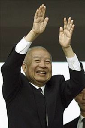 Cambodia's then King Norodom Sihanouk (left) and Queen Monineth wave to the crowd upon their arrival at the annual boat racing festival in Phnom Penh in 2001.