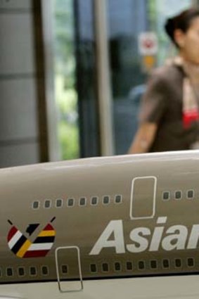 An employee of Asiana Airlines walks past its model plane on display in Seoul.