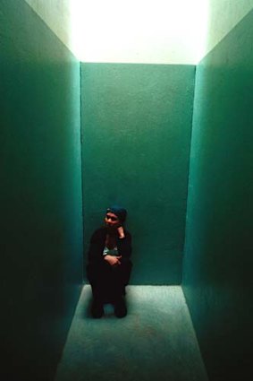 Tour guide and former political prisoner Dawn Elliot sits in an isolation cell at the Apartheid Museum.